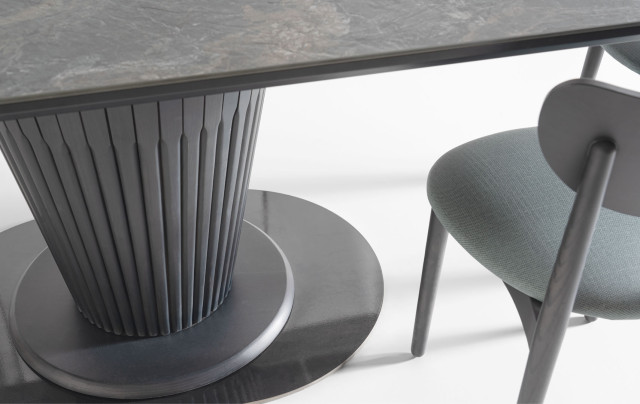 The Konus Oval table features an inverted conical base with a circular wooden bottom trim and an oval steel metal base that provides stability.<br>The lacquer of the metal base is transparent as a standard finish.