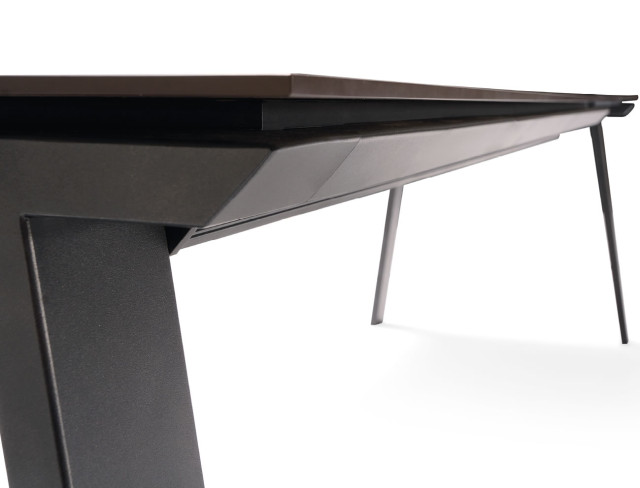 Detail of the side piece that joins the two legs giving continuity to the design of the table.