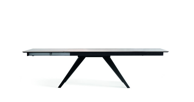 Dragon features a synchronized extension system that allows this central pedestal table to extend without having to split the main tabletop into two pieces. By gently pushing the tabletop, it slides to one side, and the extension appears underneath on the opposite side. Once extended, the table is perfectly symmetrical. In this way, when the table is closed, the tabletop is a single piece, and when extended, the tabletop design remains seamless across the extension.